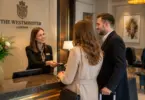 Hotel receptionist welcoming guests at the reception desk of Thistle Park Lane in Westminster, London.